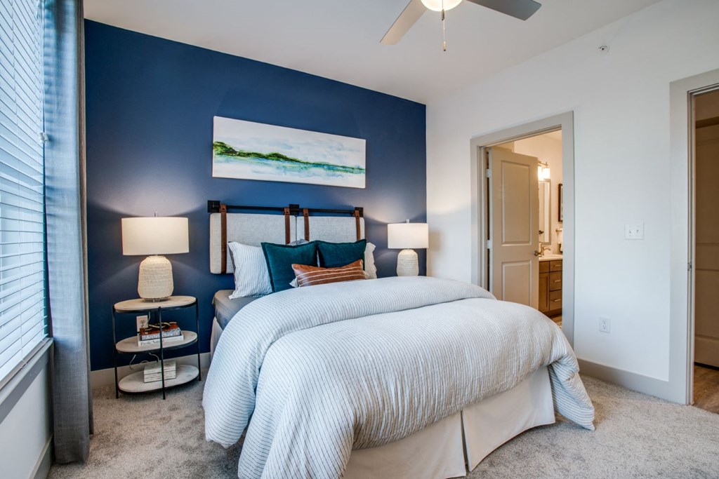 a bedroom with two beds and a blue accent wall