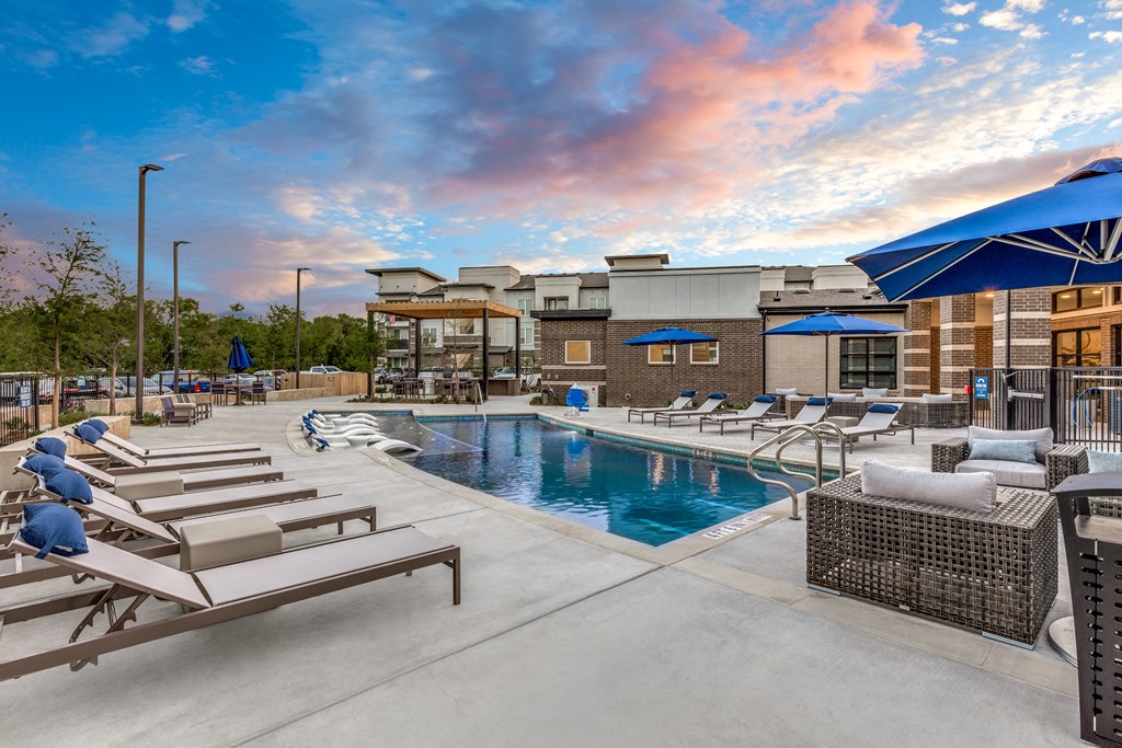 a swimming pool with lounge chairs and umbrellas at the resort at governors crossing
