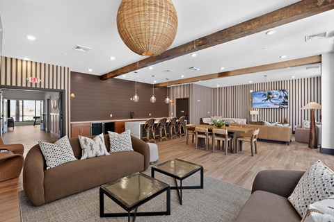A living room with a brown couch and a glass coffee table.