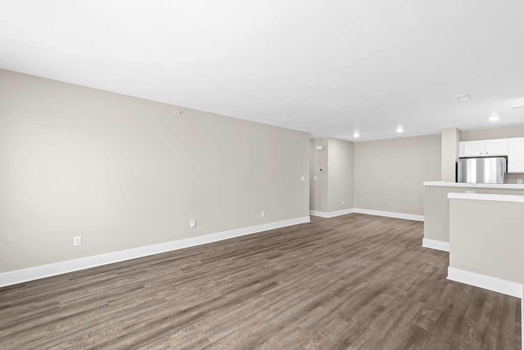 an empty living room with wood flooring and a window