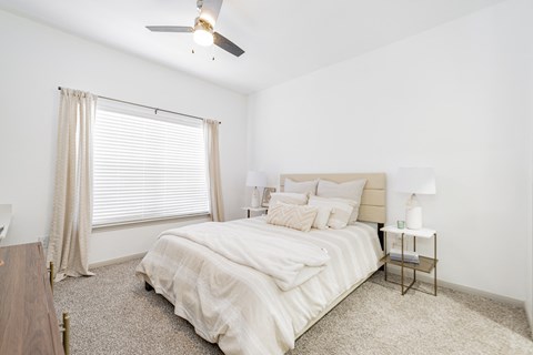 a bedroom with a bed and a ceiling fan