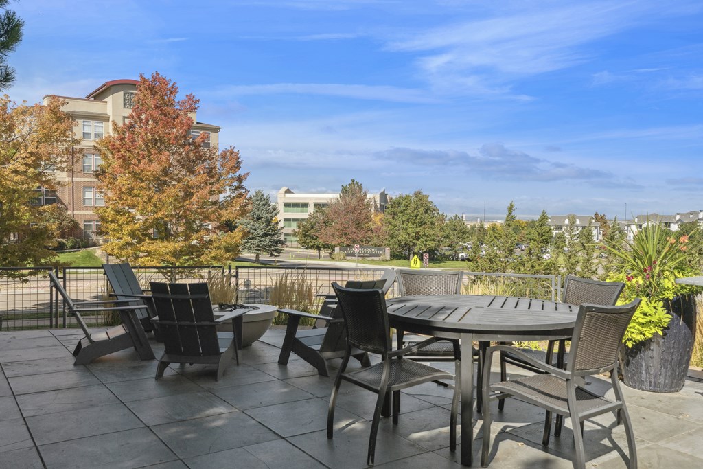 A patio with a table and chairs overlooking a city.