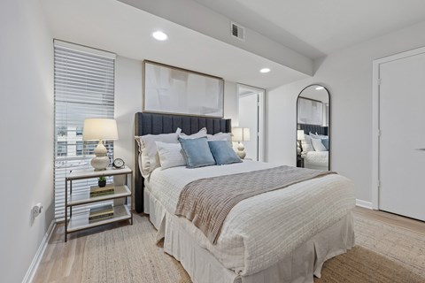 A bedroom with a large bed and a mirror on the wall.