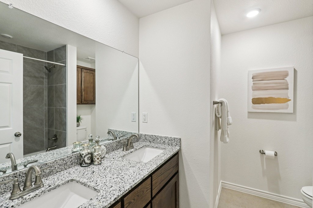 A bathroom with a marble counter top and a towel hanging on the wall.