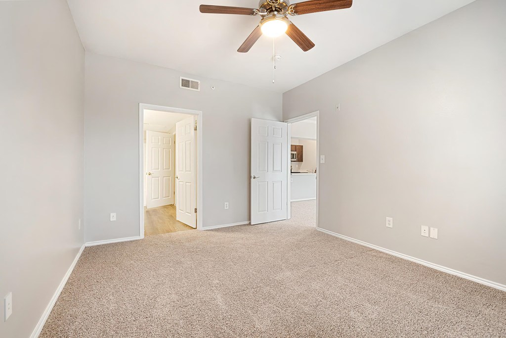 a bedroom with a ceiling fan and carpet