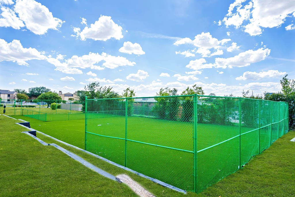 a fenced in soccer field on a sunny day