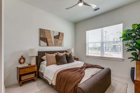 a bedroom with a bed and a ceiling fan and a window