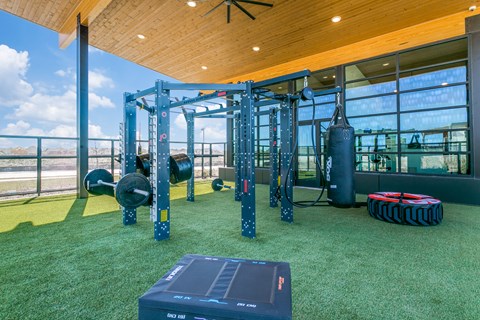 A gym with a green floor and a wooden ceiling.