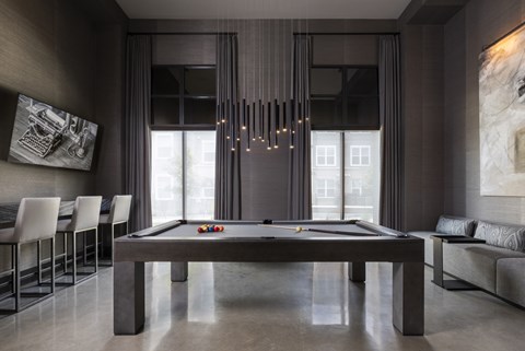 A pool table in a room with a light hanging from the ceiling.