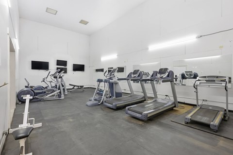 A gym with treadmills, exercise bikes, and weight machines.
