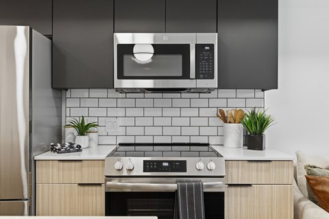 A modern kitchen with a black microwave above the stove.