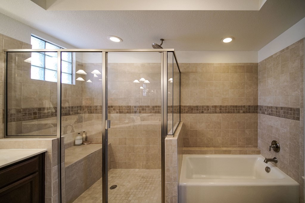 a bathroom with a tub and a shower and a sink