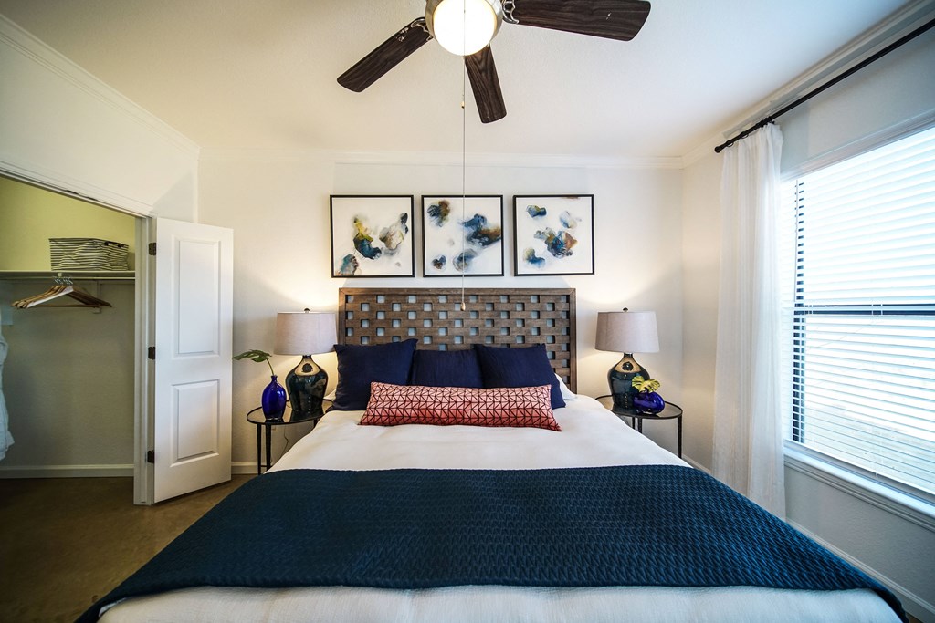 a bedroom with a bed and a ceiling fan