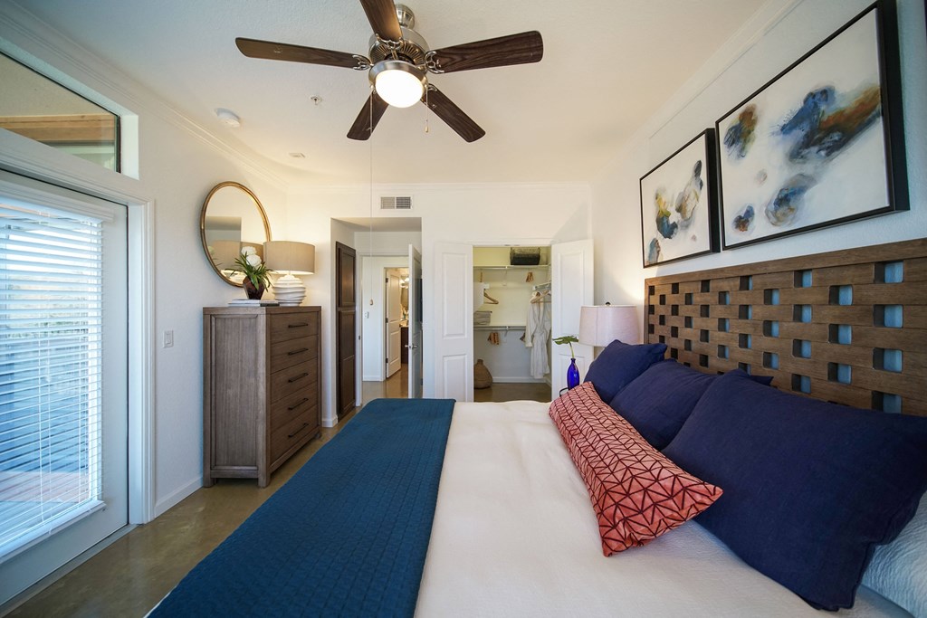 a bedroom with a large bed and a ceiling fan