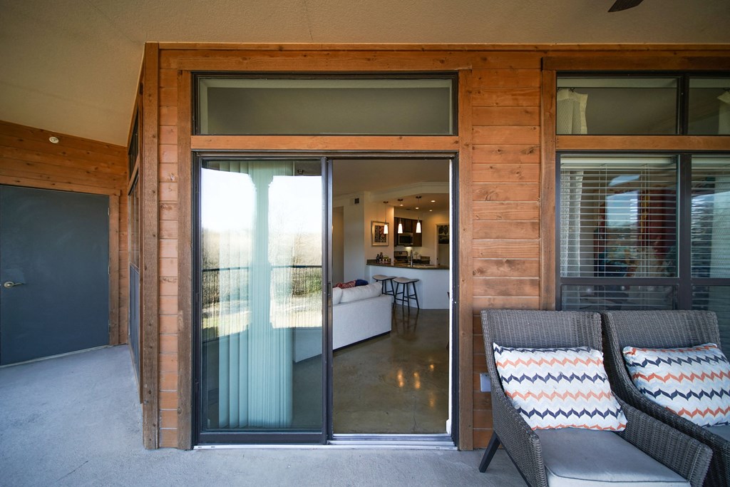 a porch with two chairs and a sliding glass door