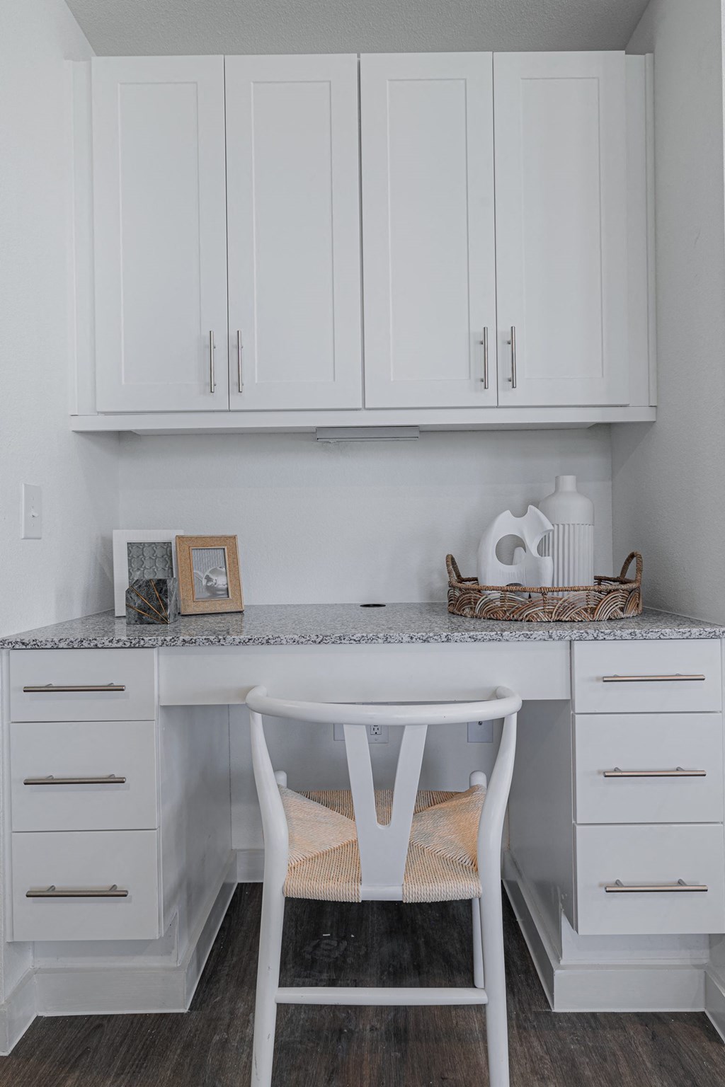 a small white desk with a white chair in a white kitchen