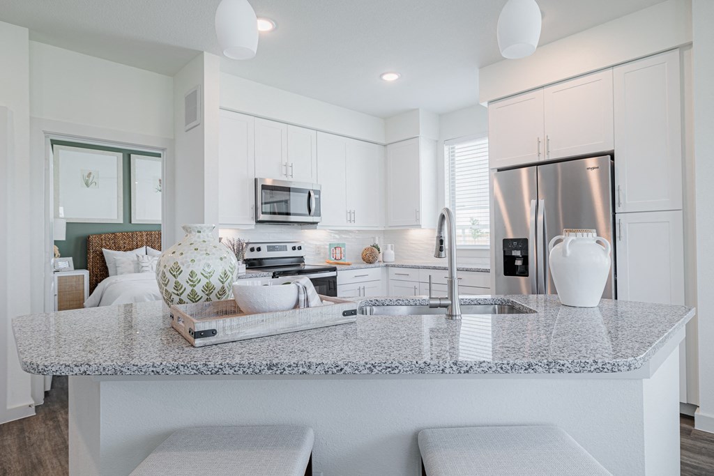 a kitchen with white cabinets and a granite counter top
