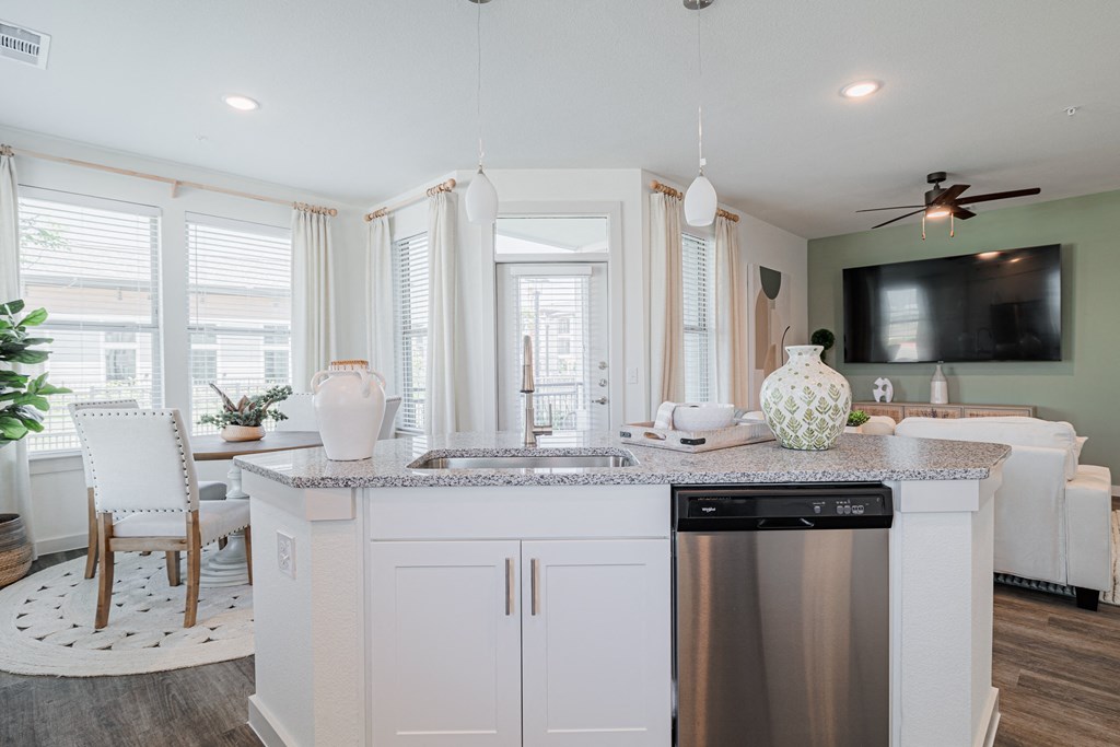 a kitchen with white cabinets and a stainless steel dishwasher