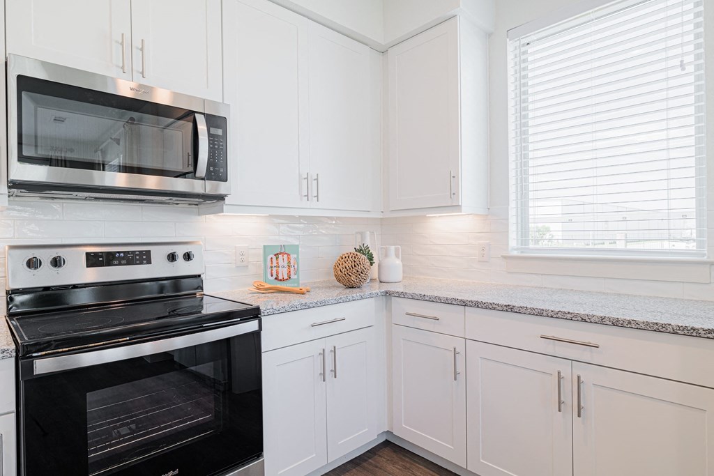 a kitchen with white cabinets and black appliances