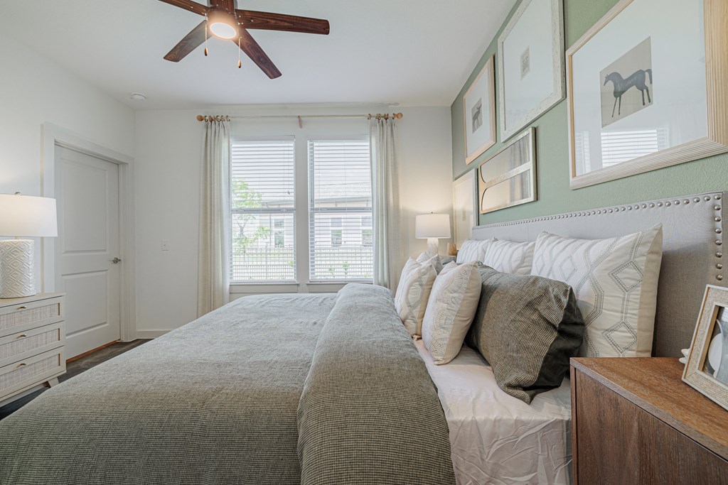 a bedroom with a large bed and a ceiling fan