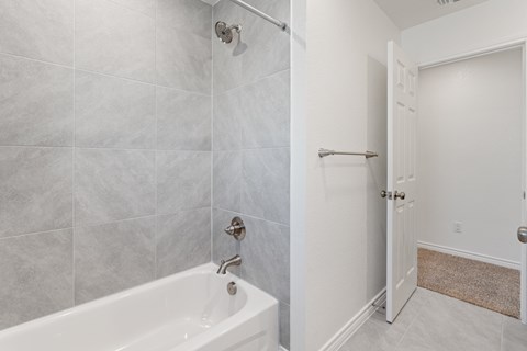 a bathroom with a tub and a shower and a door