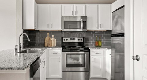 A modern kitchen with a stove, oven, microwave, and refrigerator.