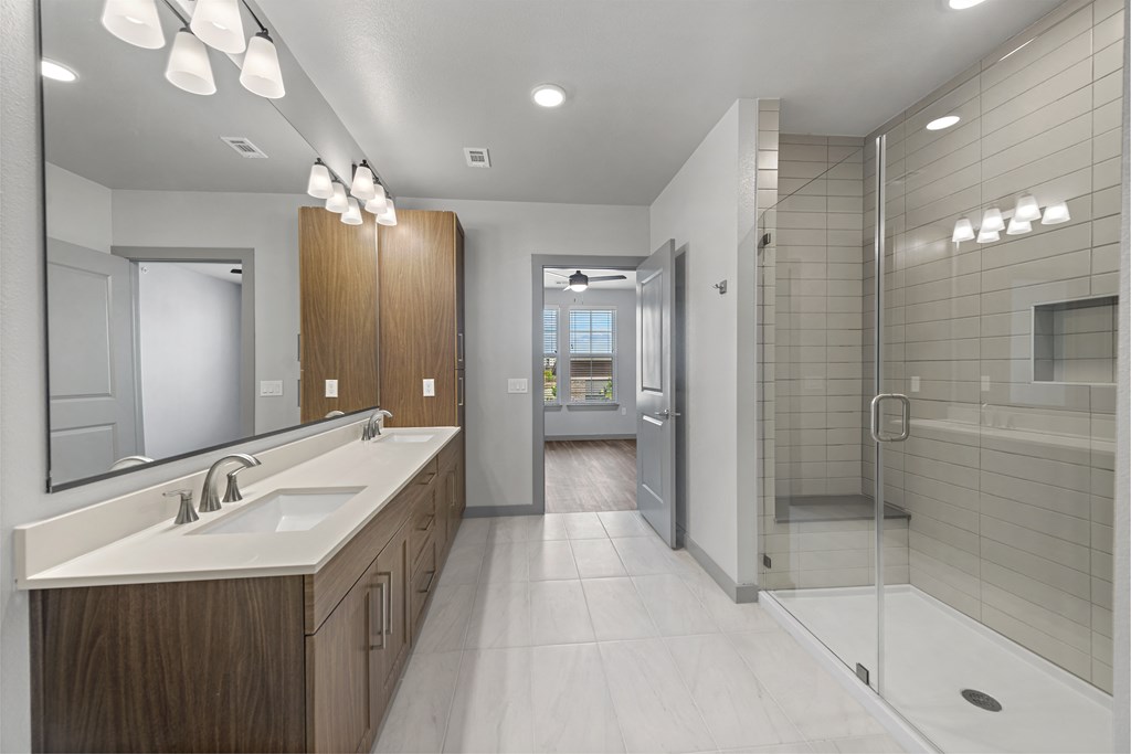 a bathroom with a shower and a sink and a mirror