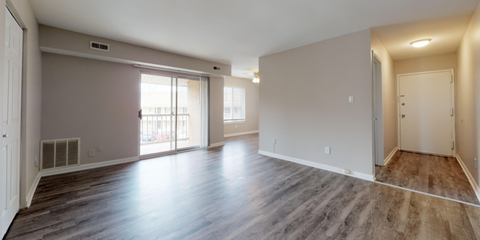 the living room and dining room of an empty apartment with wood flooring