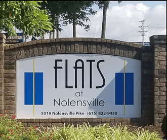 a sign for flats at noellville at the entrance to the gas station