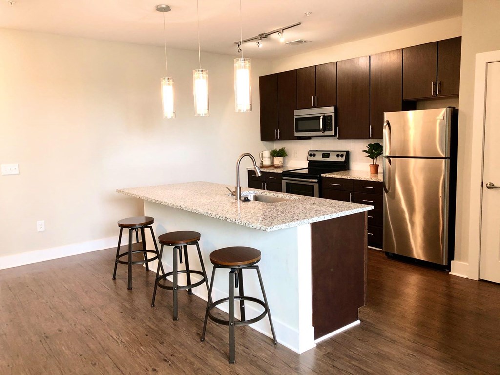 a kitchen with a large island with three stools