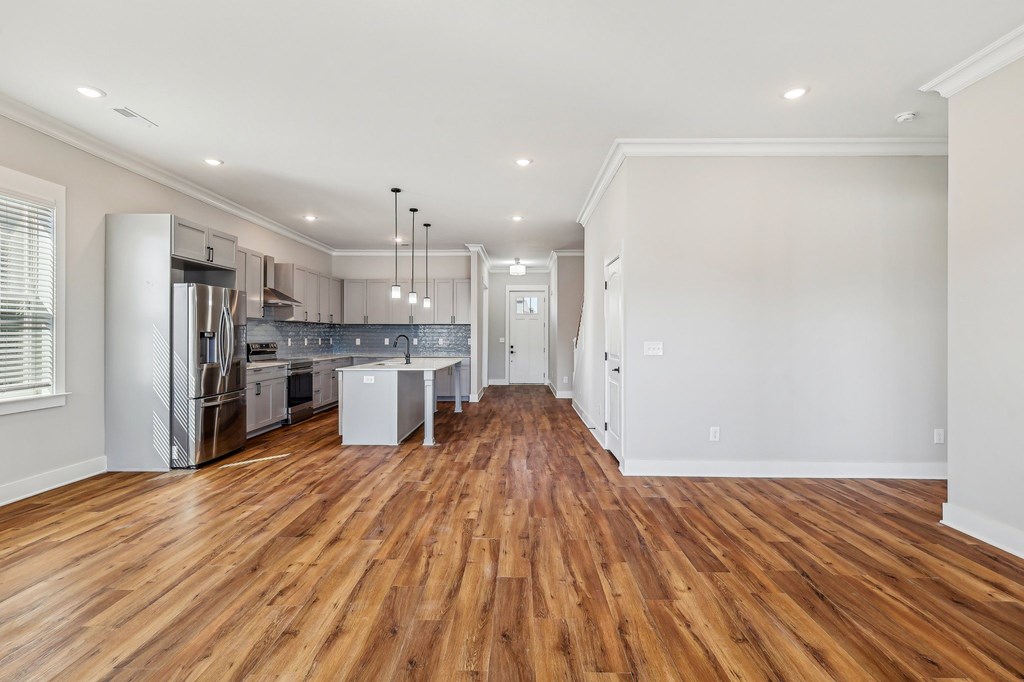 A kitchen with wooden floors and white walls.