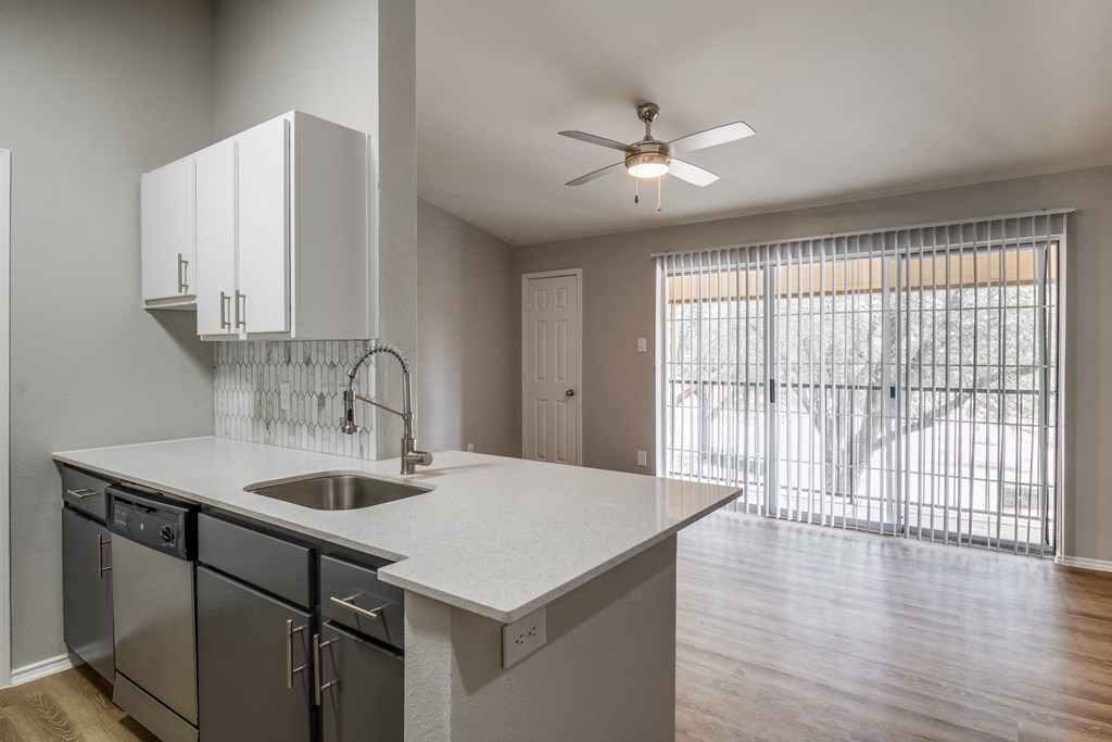 a kitchen with a large window and a ceiling fan