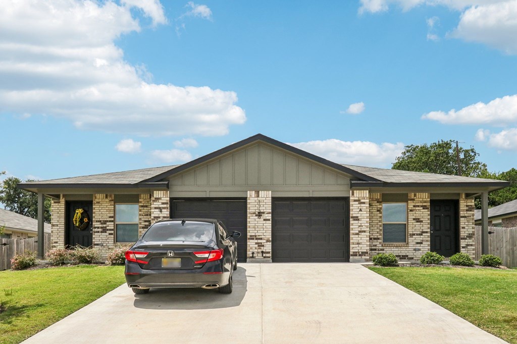 A car is parked in front of a garage.