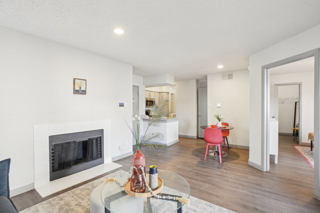 A living room with a fireplace and a glass table.