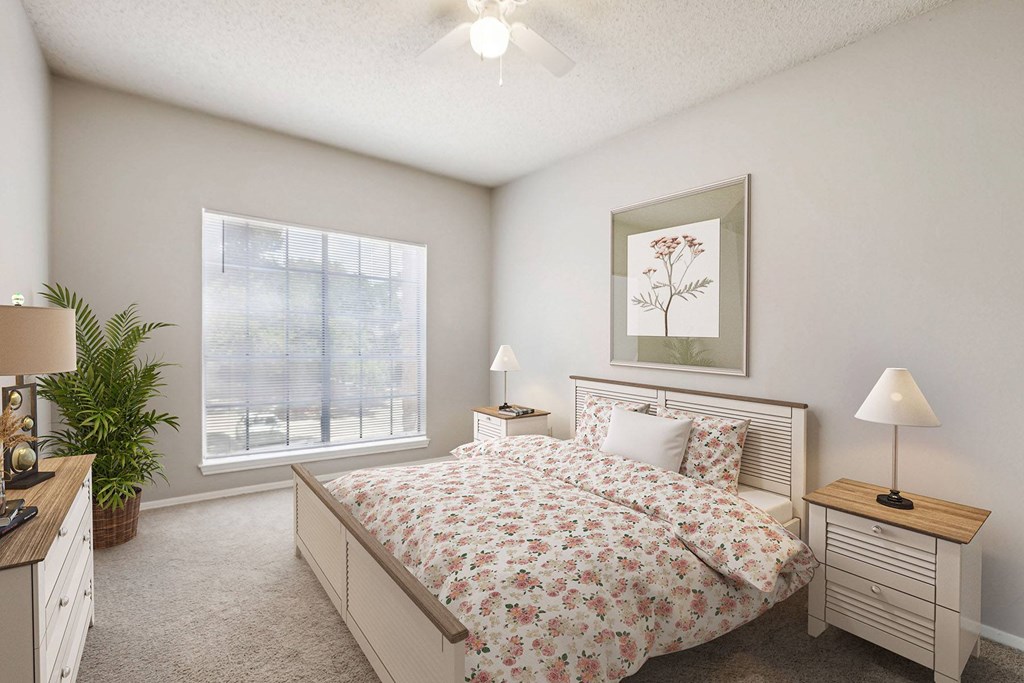 A bedroom with a large bed and a ceiling fan.