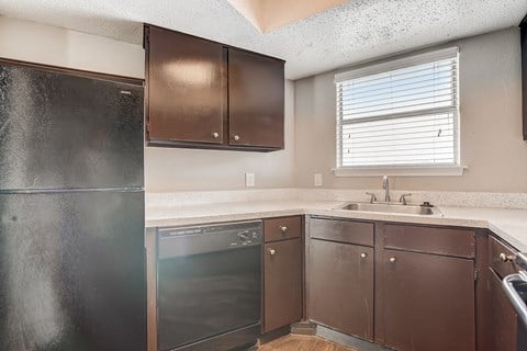 a kitchen with a dishwasher and a sink and a refrigerator