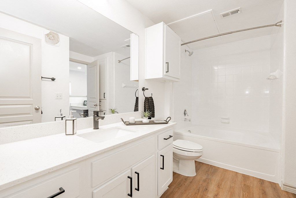 a bathroom with white cabinets and a sink and a toilet
