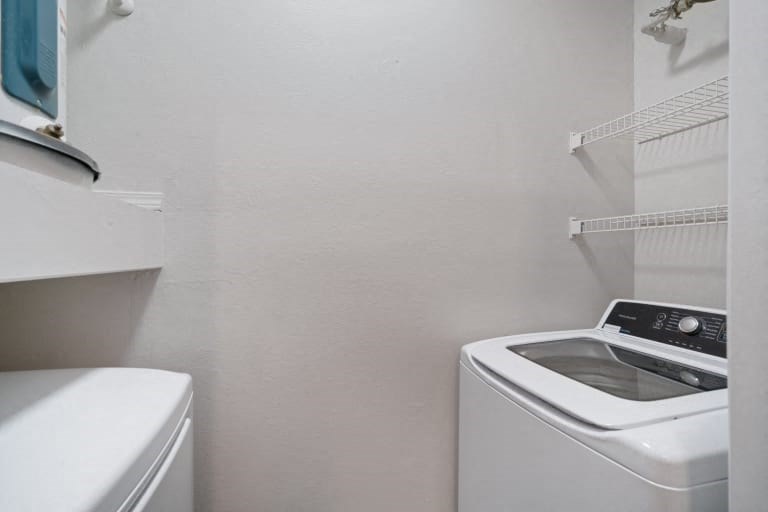 a white washer and dryer in a small laundry room