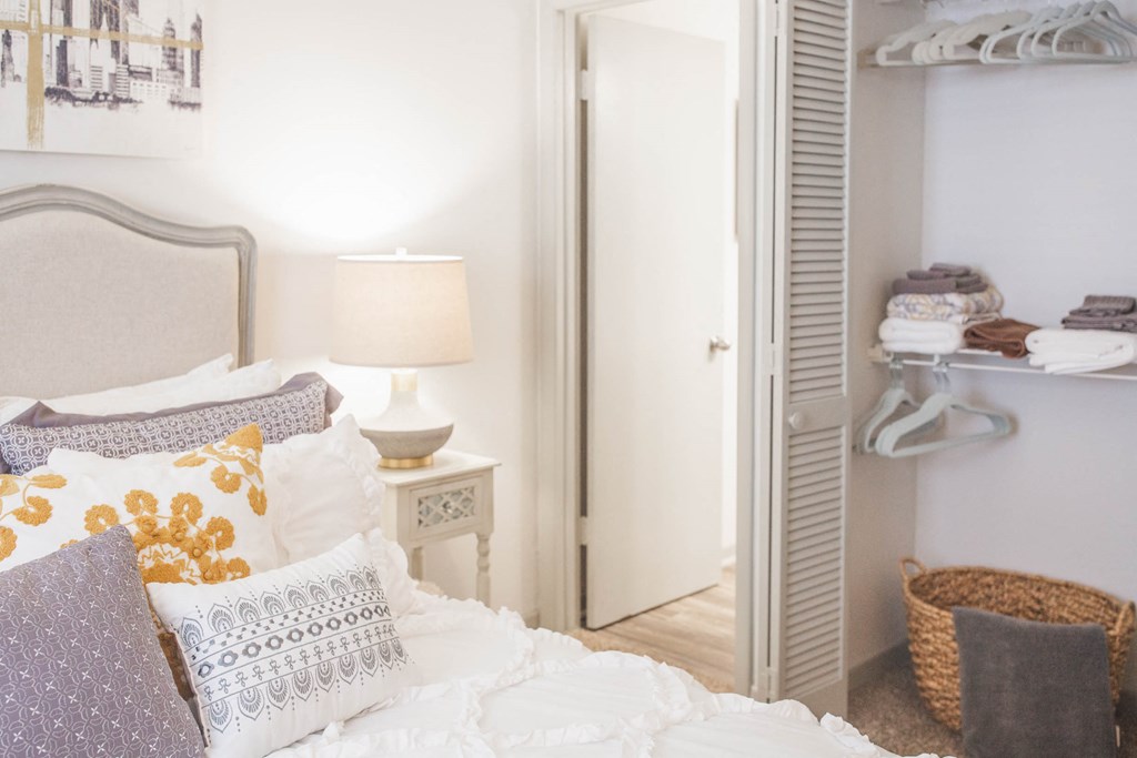 a bedroom with a bed with pillows and a closet