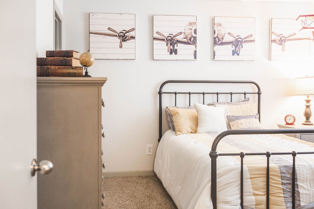 a bedroom with a bed and pictures of airplanes on the wall