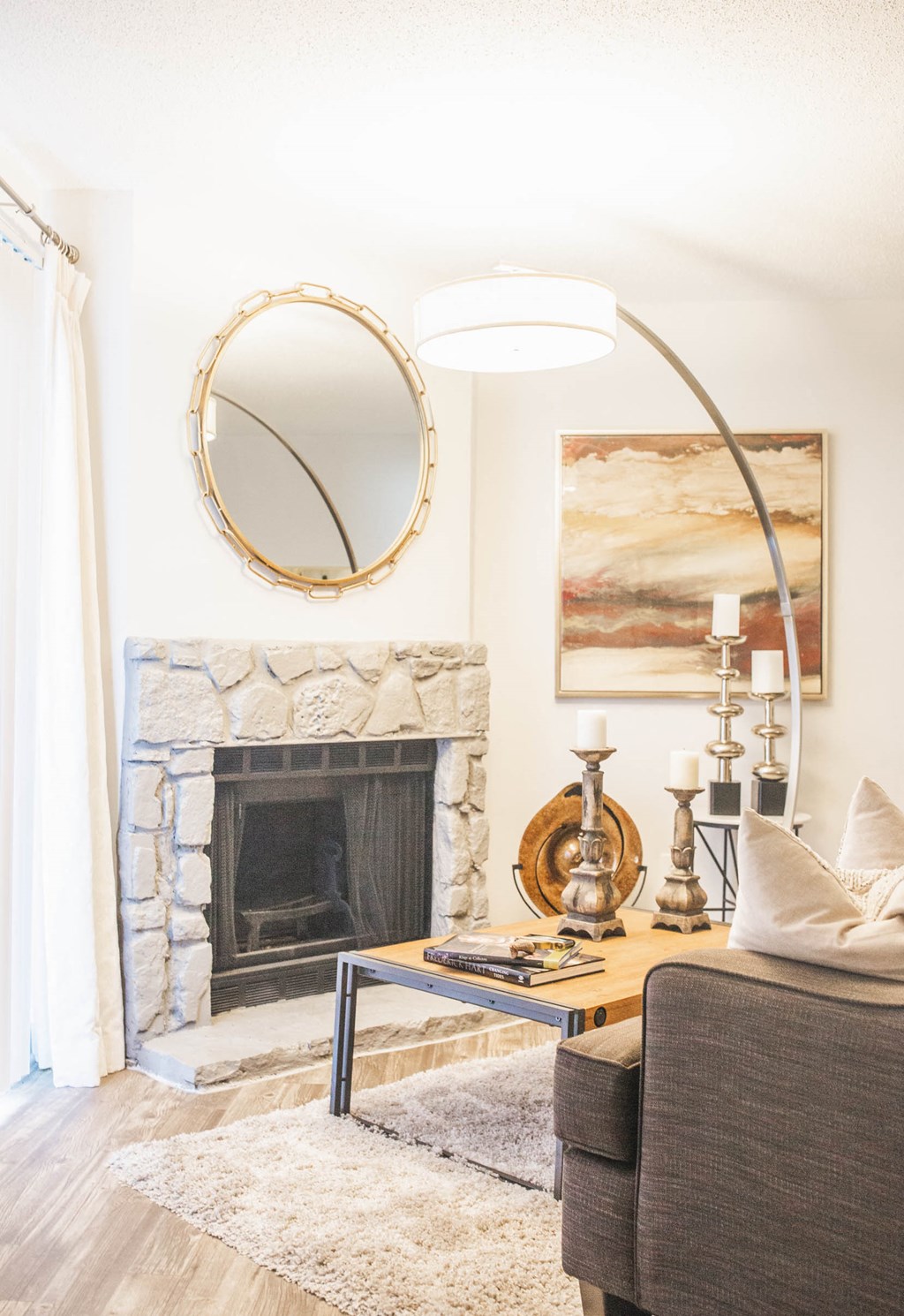 a living room with a fireplace and a mirror above it