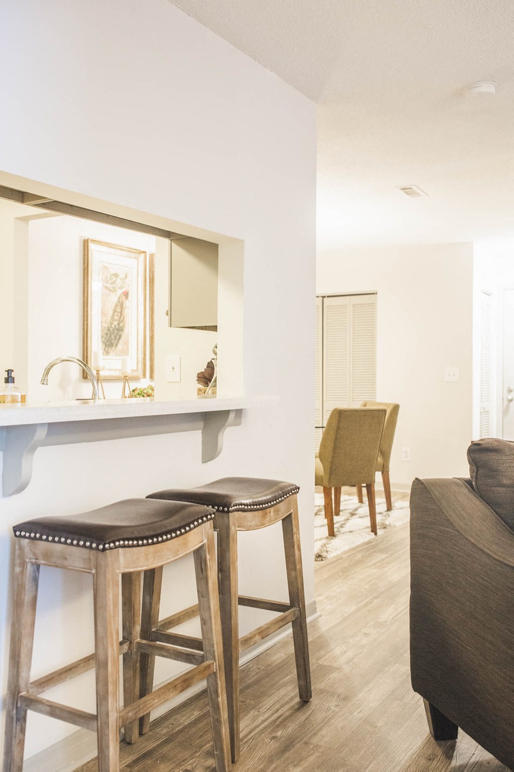 a bar with two stools in a living room with a couch