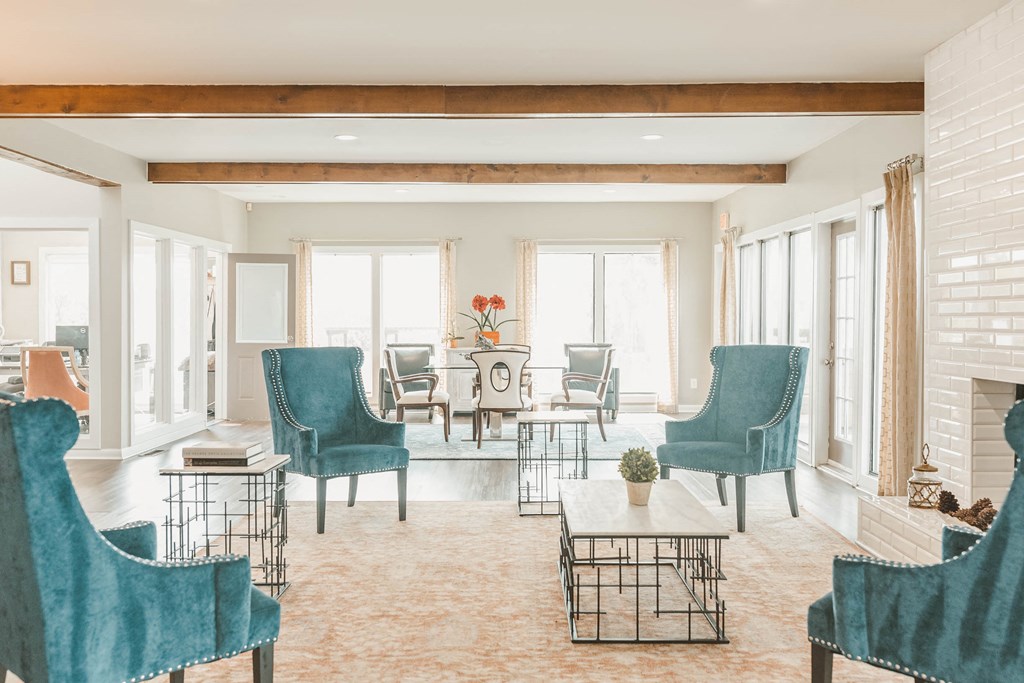 a living room with blue chairs and a fireplace