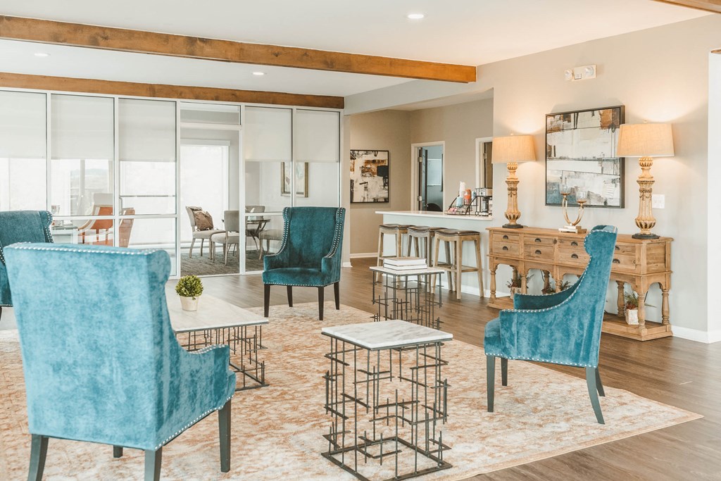 a living room with blue chairs and a dining table