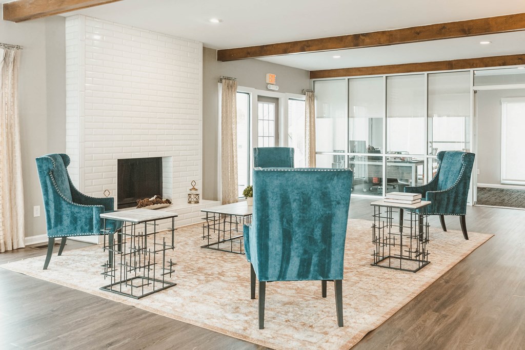 a living room with blue chairs and a fireplace