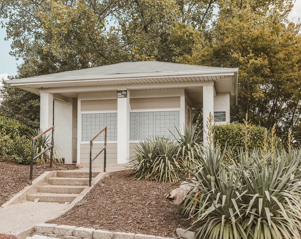 a small building with steps and plants in front of it