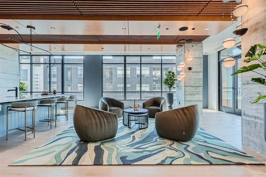 a lounge area with chairs and a rug in a lobby of a building