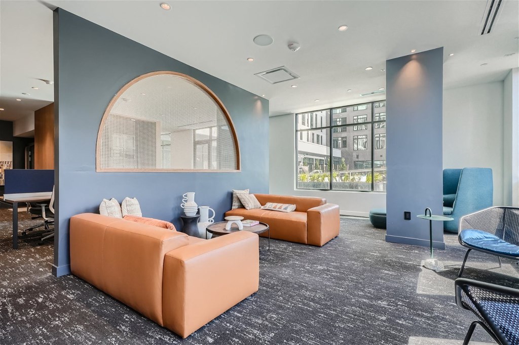 a lounge area with couches and chairs and a large window