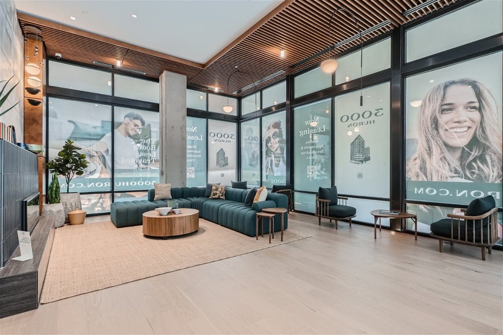 a lobby with large windows and a couch and a table