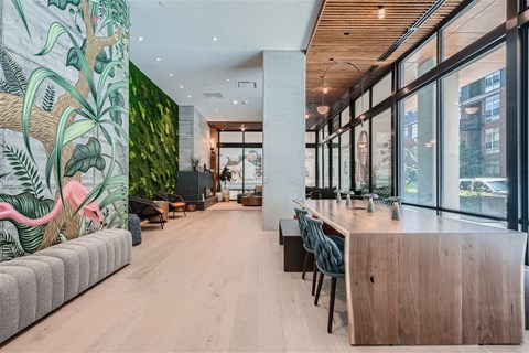 the lobby of a hotel with a long bar and a wall of plants